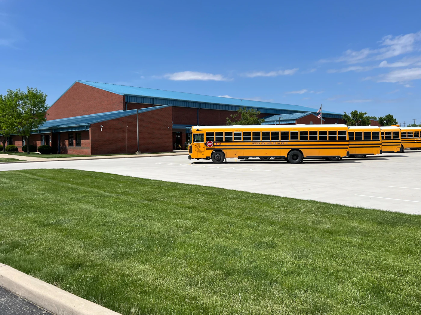 A school building with buses lined up outside